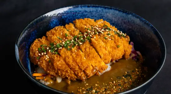 Crispy chicken katsu served over fluffy rice with fresh cabbage, rich Japanese curry sauce & tonkatsu drizzle, finished with
