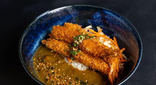 Crispy chicken katsu served over fluffy rice with fresh cabbage, rich Japanese curry sauce & tonkatsu drizzle, finished with
